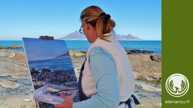 Une femme fait de la peinture au bord de la mer