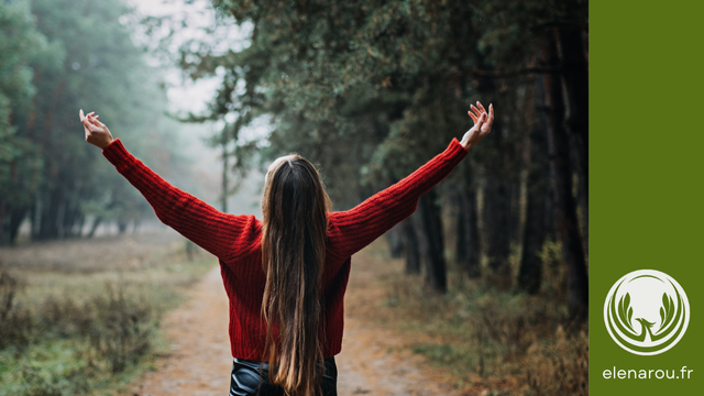 une femme ouvre les bras vers le ciel dans la Nature